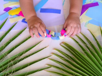 Close up hand Happy kids doing arts and crafts together at their desk. Child Make Paper Colorful Garland For Sukkah-Jewish Holiday.